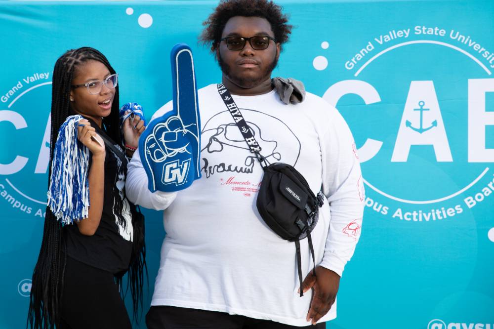 two students posing with foam fingers in front of CAB backdrop at Laker Kickoff photo booth